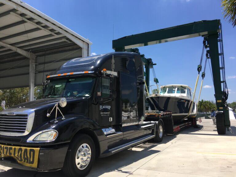 Yacht being lifted for loading onto flatbed truck – heavy boat transport